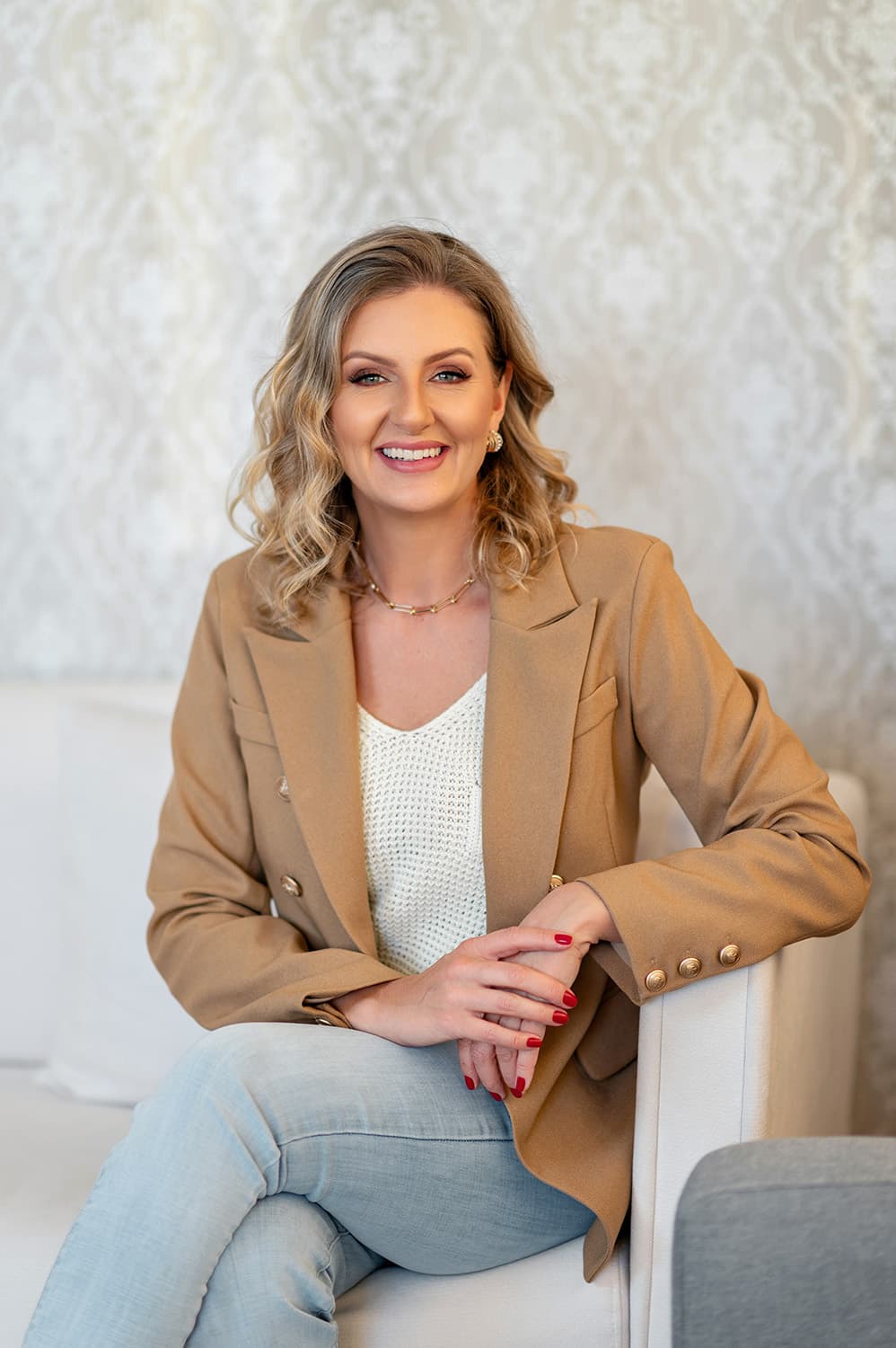 Andrea Bonfim, nutricionista, sorrindo sentada em uma cadeira